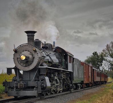 An Antique Restored Steam Freight Train Approaching Head on Blowing Smoke and Steam