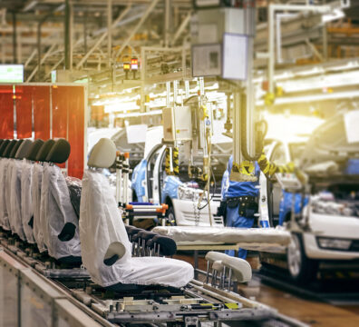 In a large factory, the car seat installation line is working.